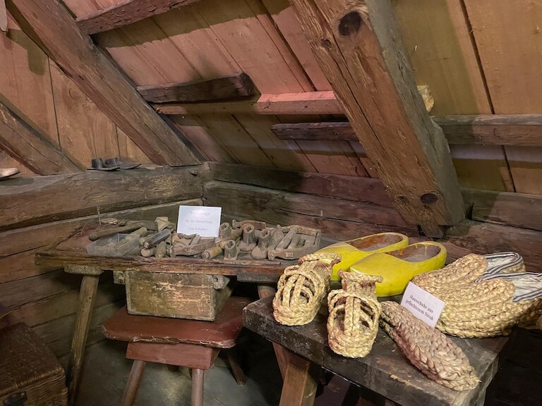 Werkzeuge zur Herstellung von Holzschuhen sowie geflochtenes Schuhwerk aus Stroh geben einen Einblick in das traditionelle Handwerk der Region.