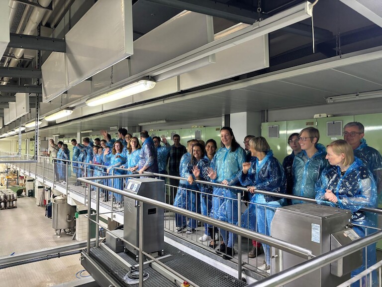 Auf der Tribüne betrachten die Lehrerinnen und Lehrer die Produktion der Getränke.
