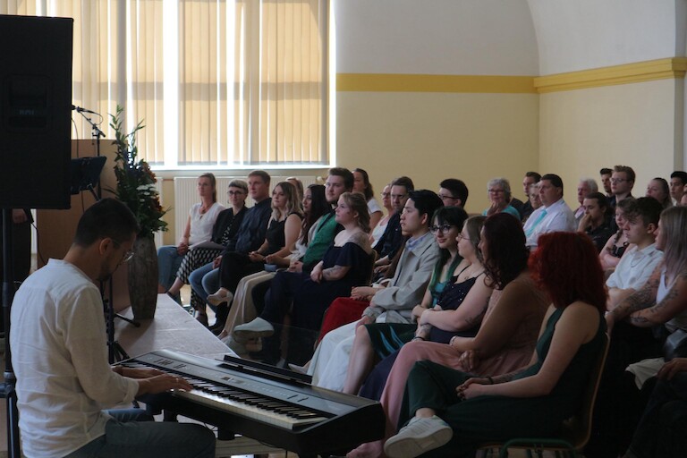 Das Publikum lauscht der Musik ausd Gesang und Keyboard.