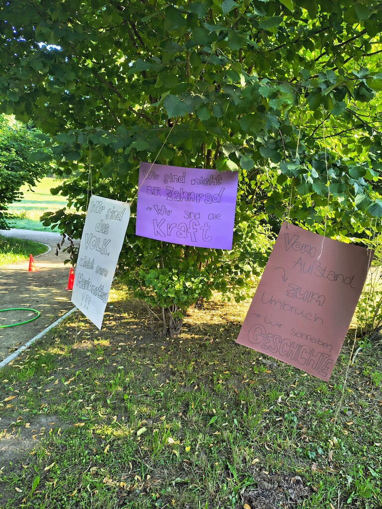 Plakate mit verschiedenen Aufschriften zur Geschichte.