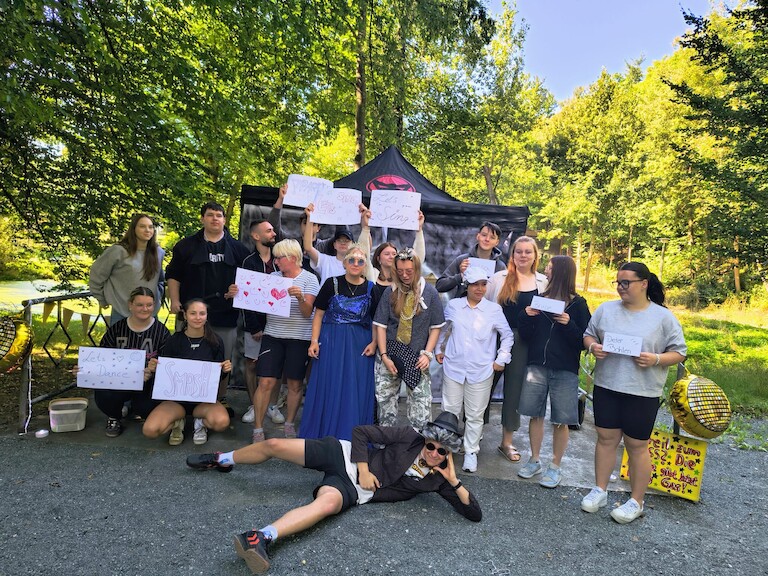 Die Klasse Sass25a steht mit ihrer Klassenlehrerin zum Gruppenfoto bereit.