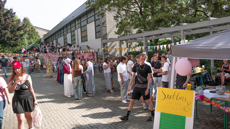 Viele Schülerinnen und Schüler sind auf dem Schulinnenhof zu sehen.