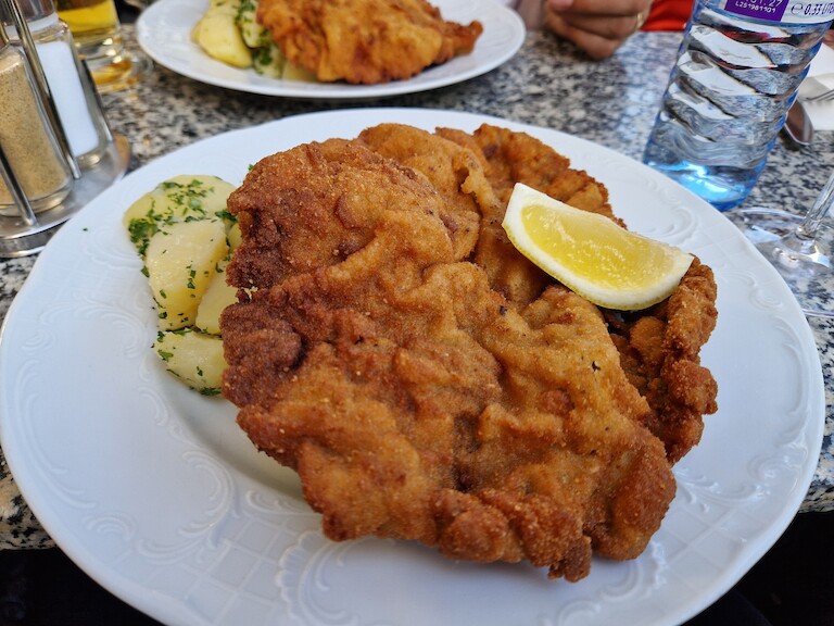 Ein Wiener Schnitzel mit Petersilienkartoffeln und Zitrone.