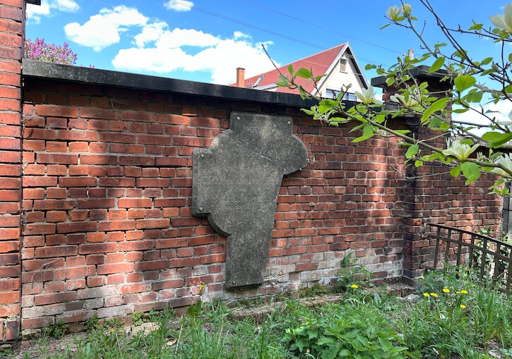 Ein Denkmal hängt an einer Ziegelmauer.