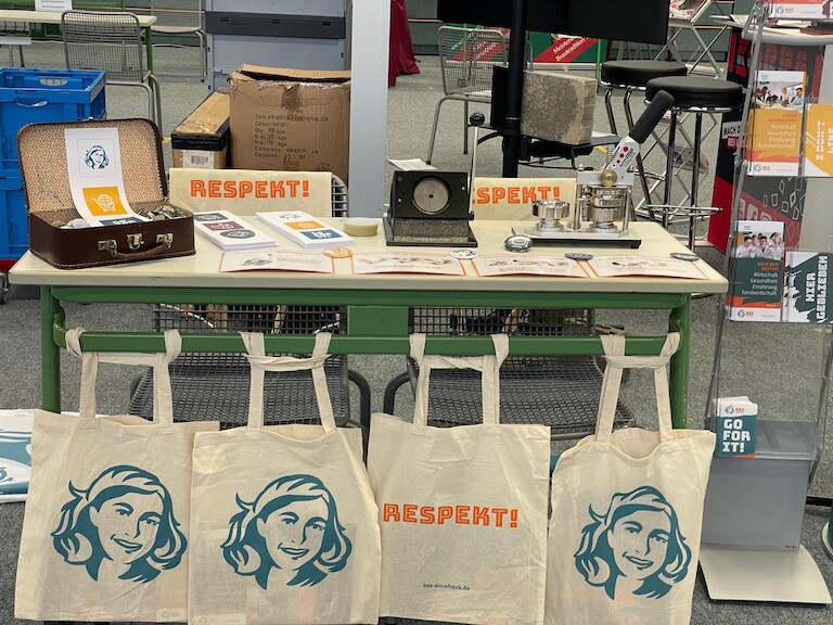 Unser Stand mit Stoffbeuteln vor dem Tisch. Die Buttonmaschine steht auf dem Tisch