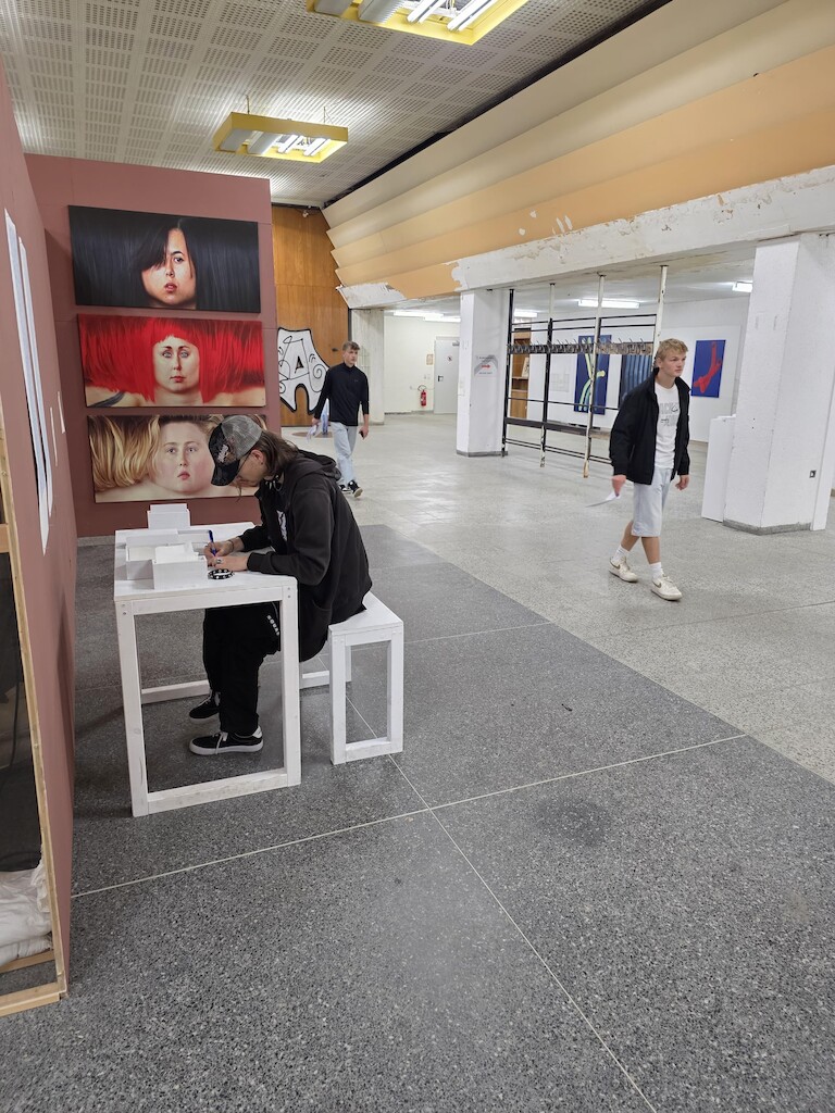 Schüler schauen sich die Ausstellung an.