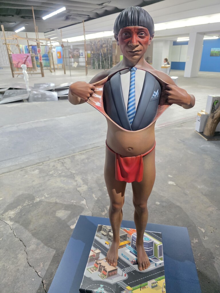 Ein Skulptur eines Ureinwohner Amerikas, der seine Haut auszieht und eine Anzug erscheint.