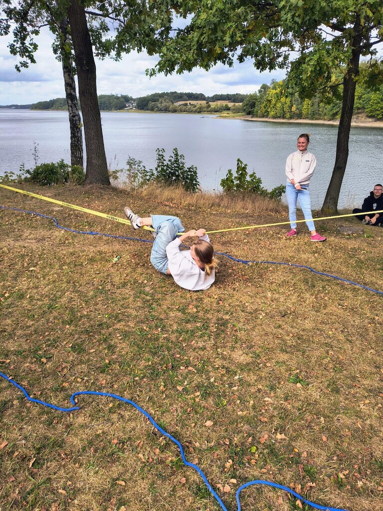 Eine Schülerin hängt an der Line und versucht sich auf eine Seite zu ziehen.