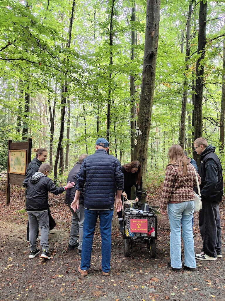 Die Teilnehmer, Schülerinnen und Schüler sind um den Hndwagen verteilt