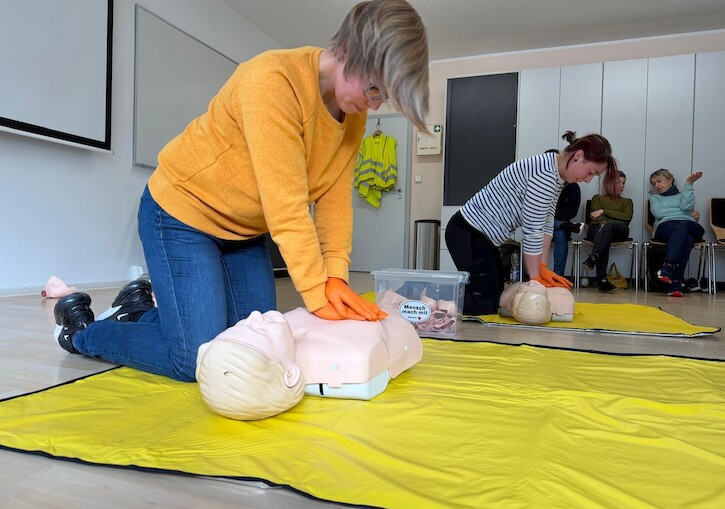 Die Lehrkräfte üben die Herzdurckmassage für dne Ernstfall.