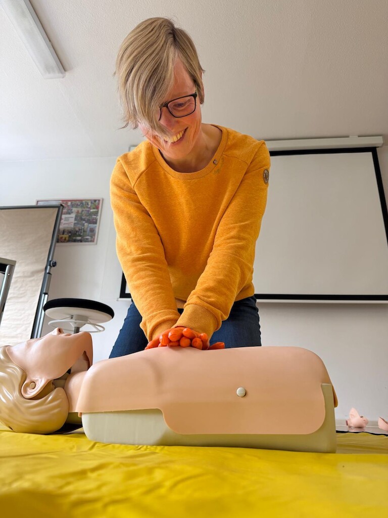Die Teilnehmerin führt an der Puppe die Herzdruckmassage durch.