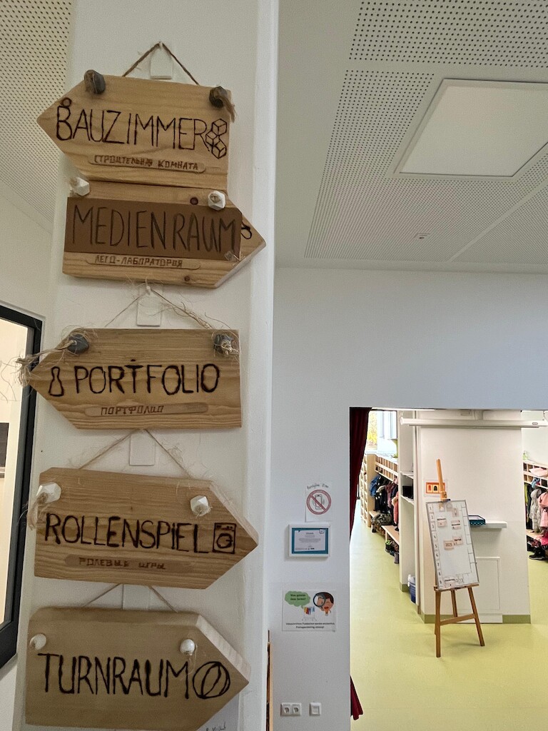 Verschiedene Schilder an der Wand zeigen den Weg zu dne einzelnen Räumen.