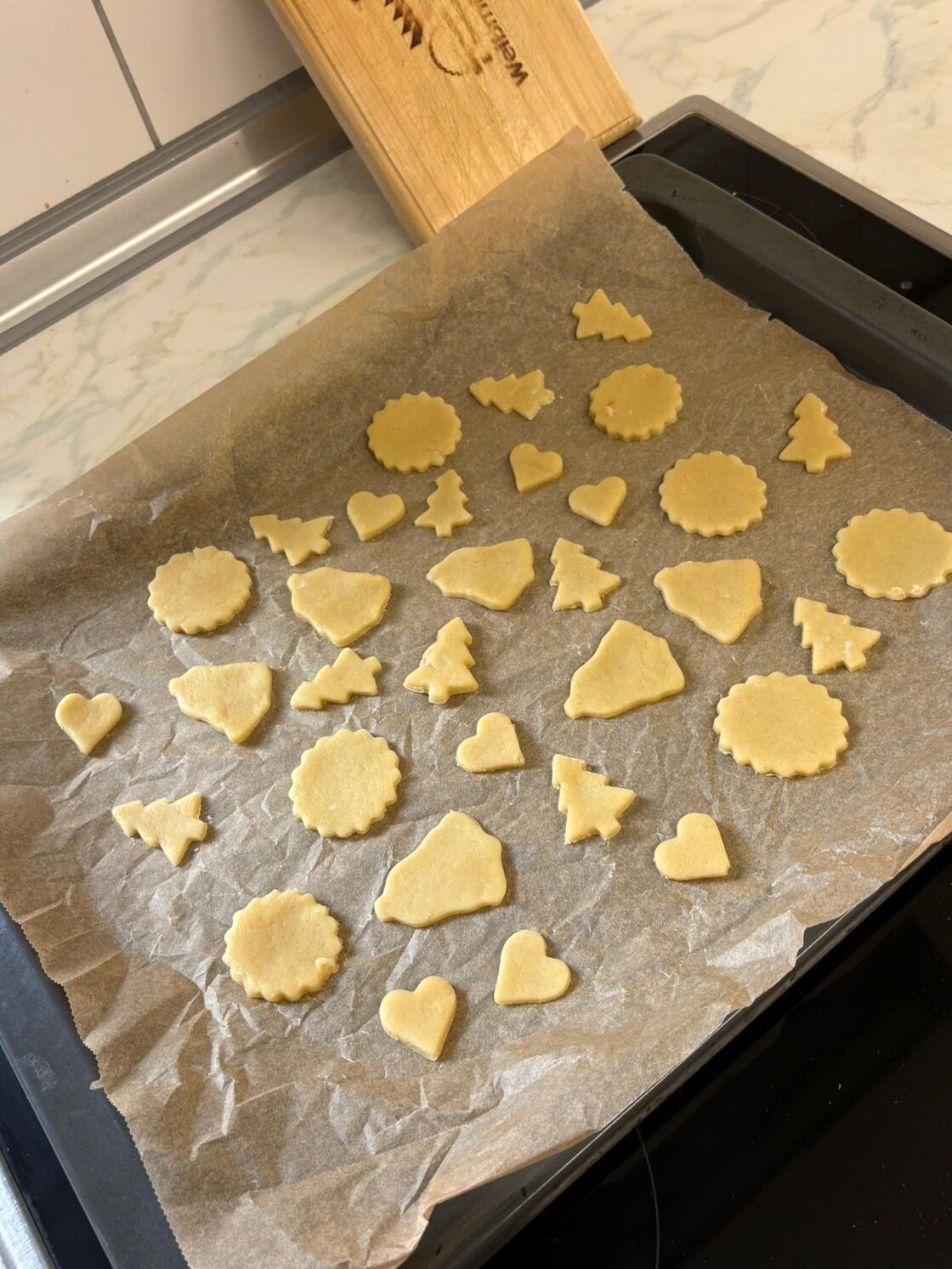 Plätzchen in verschiedenen Formen auf dem Blech.