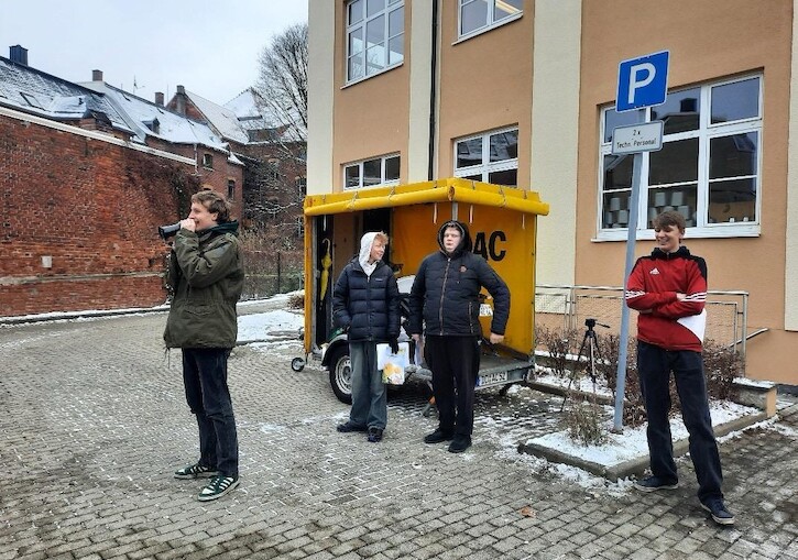 Ein Schüler macht eine Durchsage mit dem Mikrofon dem ADAC Mobil.
