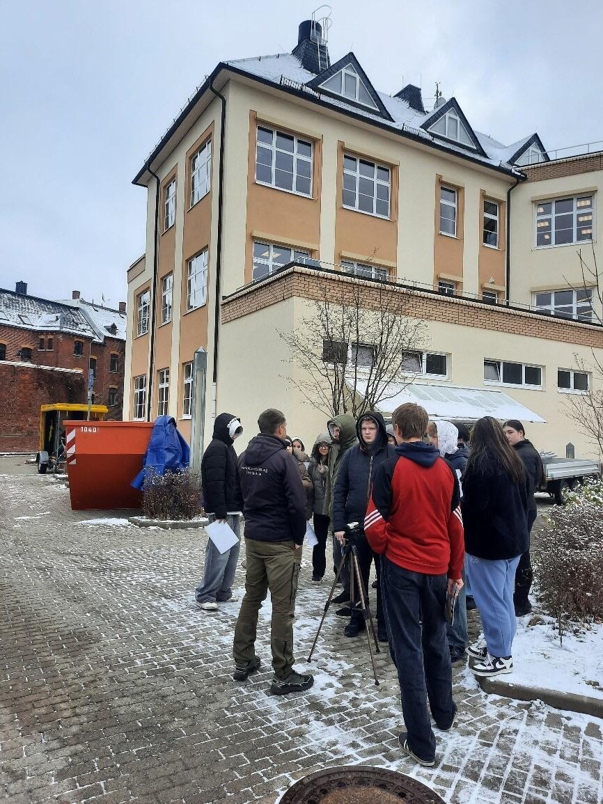 Schülerinnen und Schüler stehen im Innenhof der Schule.
