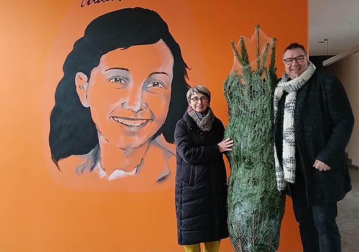 Unsere Schulleiterin und Herr Petzold vor dem Anne Frank Bild mit der Tanne.