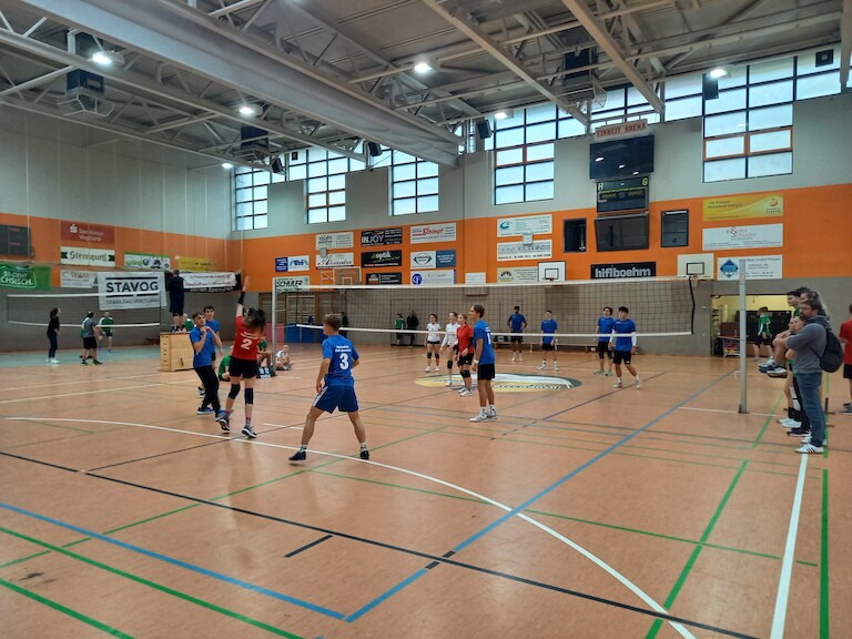 Zwei Mannschaften beim Volleyball spielen.