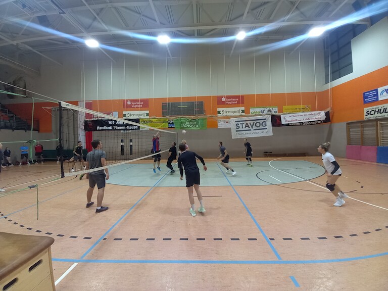 Zwei Mannschaften beim Volleyball spielen.
