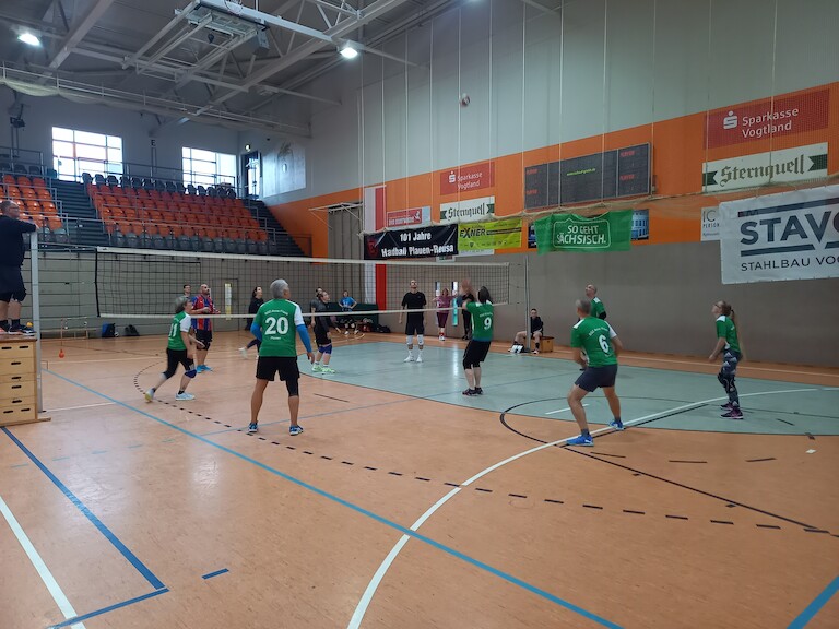 Zwei Mannschaften beim Volleyball spielen.