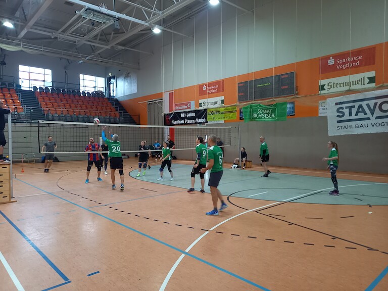 Zwei Mannschaften beim Volleyball spielen.