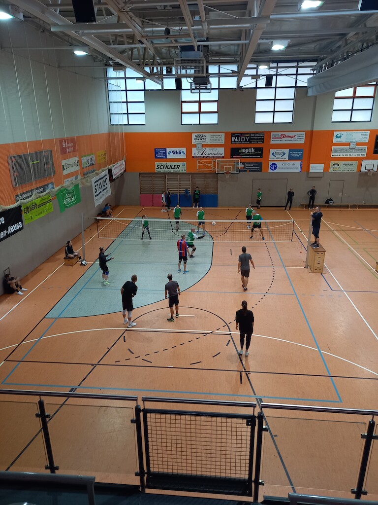 Zwei Mannschaften beim Volleyball spielen.