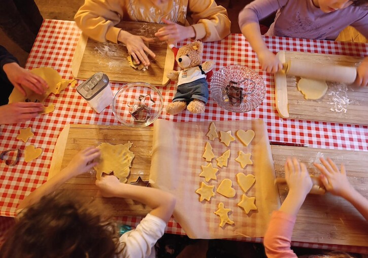 Unser Bär zwischen Kindern, die Plätzchen backen.