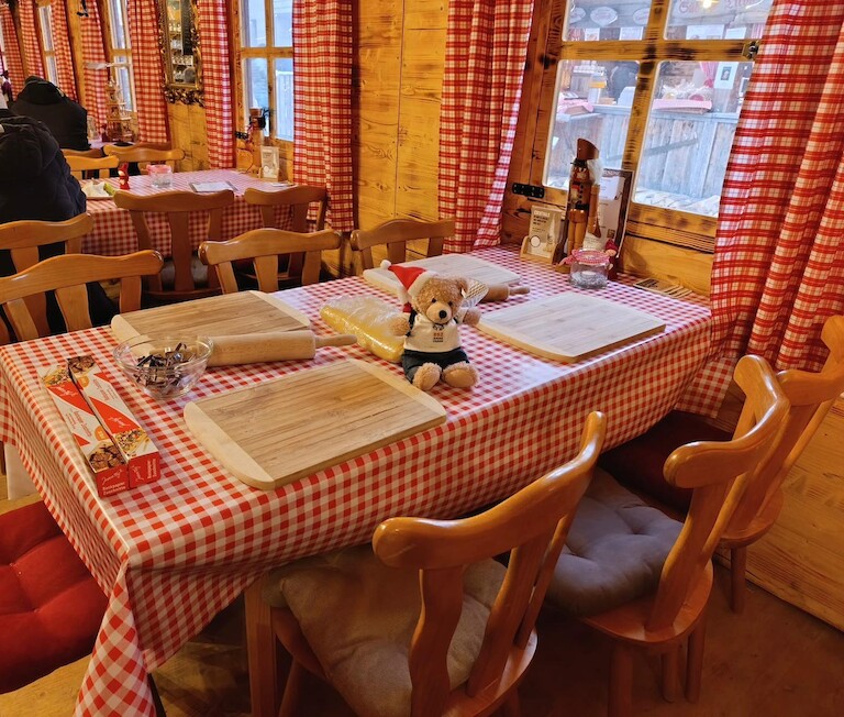 Unser Teddybär auf dem Tisch innenmitten von Teigrollen und Brettern.