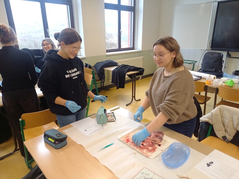 Zwei Schüler mit dem Herz auf dem Tisch.