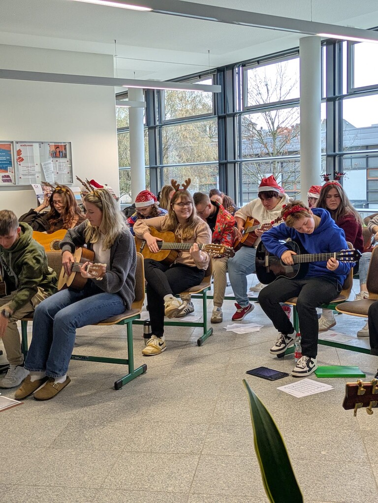 Die EZ Schülerinnen spielen auf ihren Gitarren.