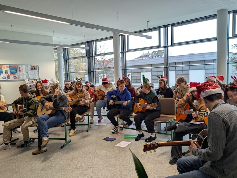 Die EZ Schülerinnen spielen auf ihren Gitarren.