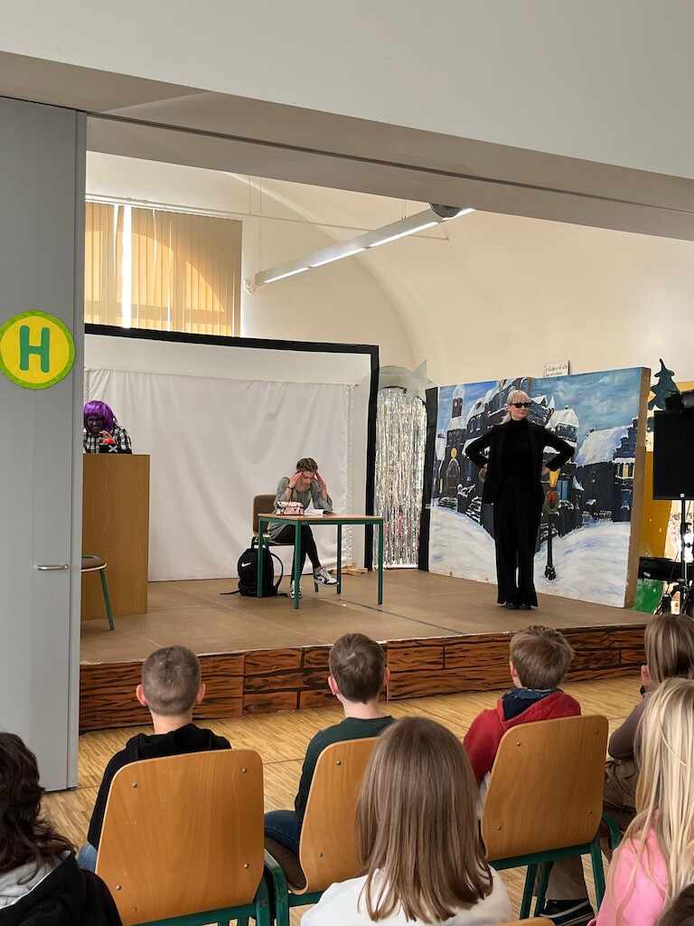 Riley sitzt genervt am Tisch.