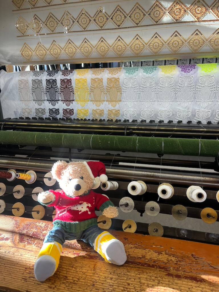 Unser Bär vor der große Stickmaschine.