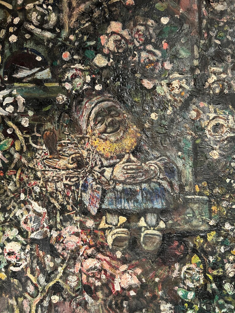 Ein Bild von einem Mann sitzend zwischen Blumen.