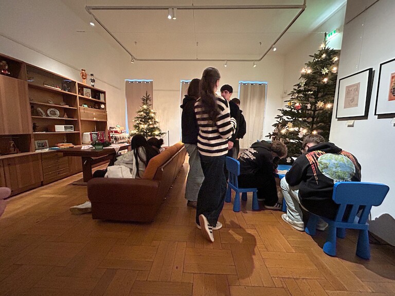 Schülerinnen und Schüler in einen festliche geschmückten alten Wohnzimmer.