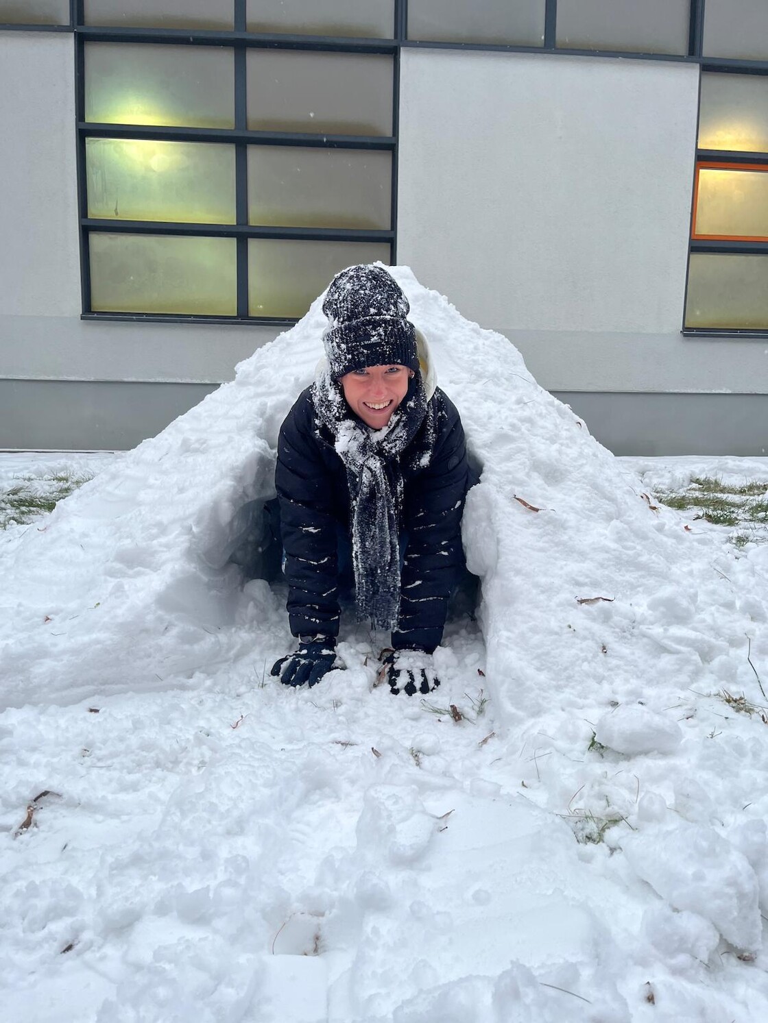 Eine Schülerin im selbstgebauten Iglu.