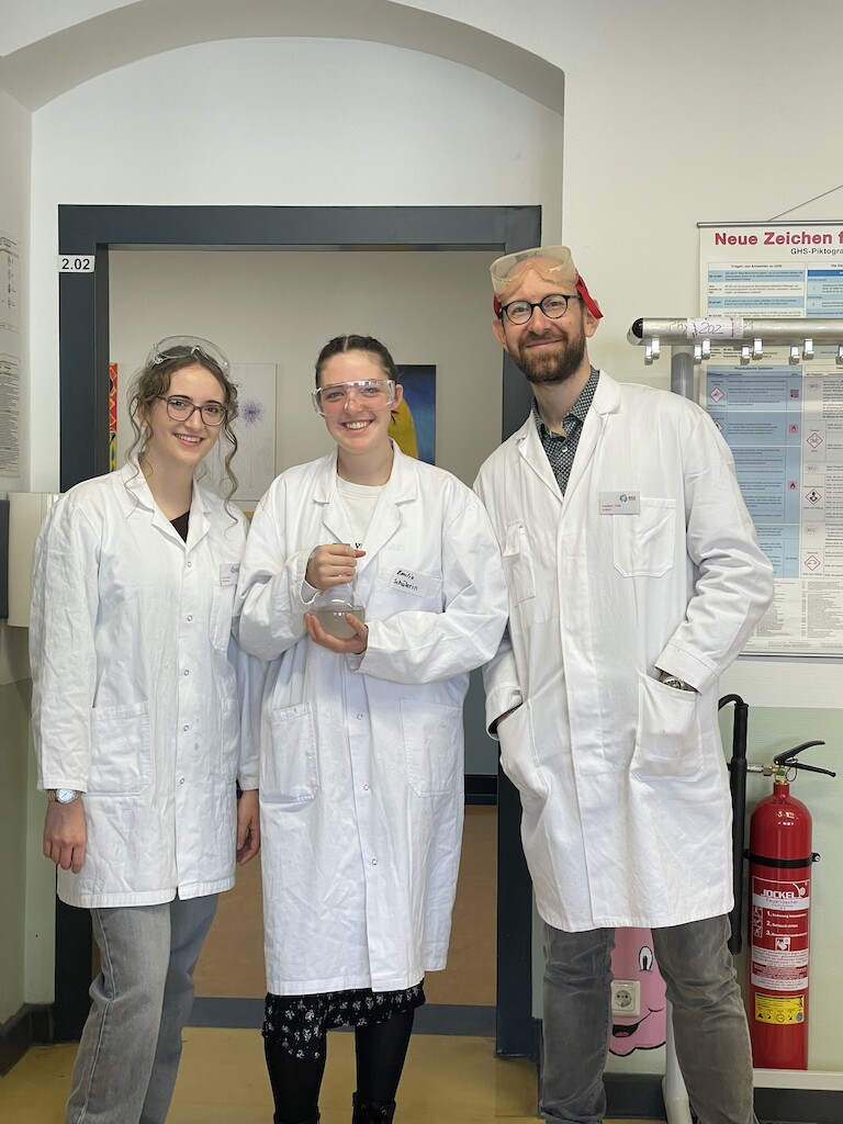 Ein Chemielehrer mit seinen Schülerinnen.