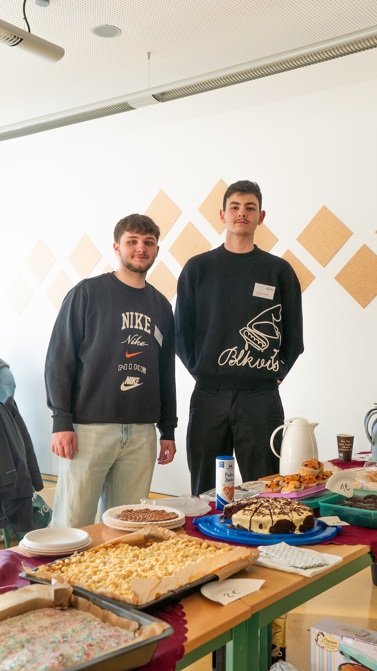 Zwei Schüler beim hinter dem Kuchenverkaufsstand.