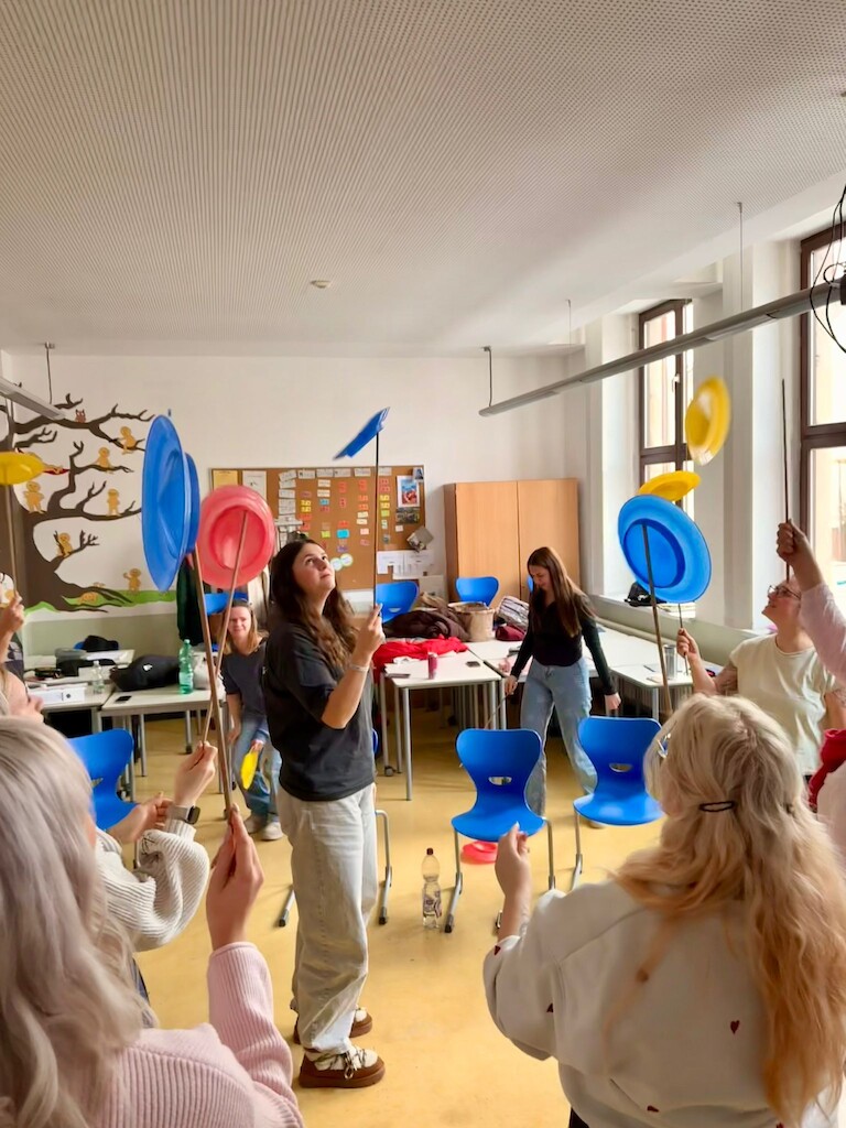 Die Schüler balancieren Teller.