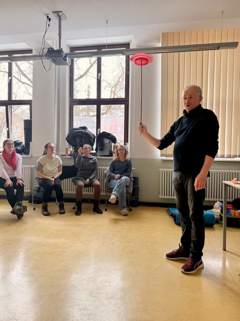 Herr Bühring zeigt das Teller balancieren.