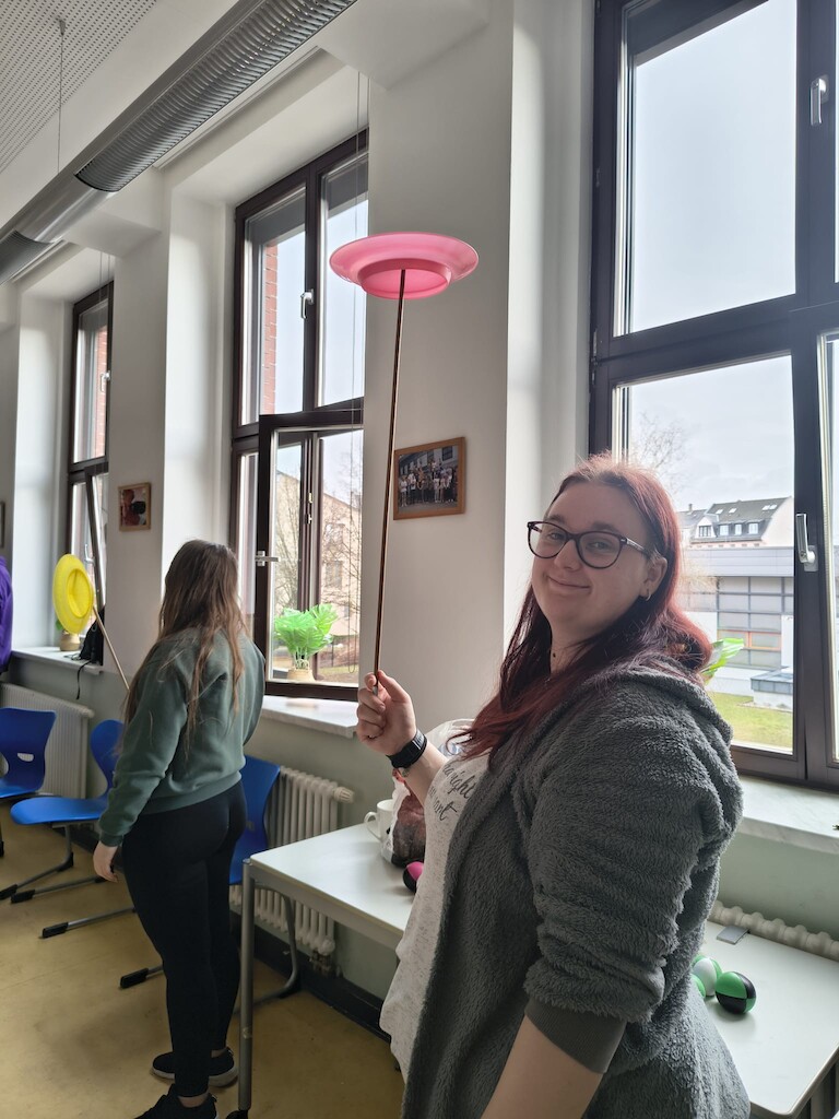 Ein Schüler balanciert den Teller auf dem Stab.