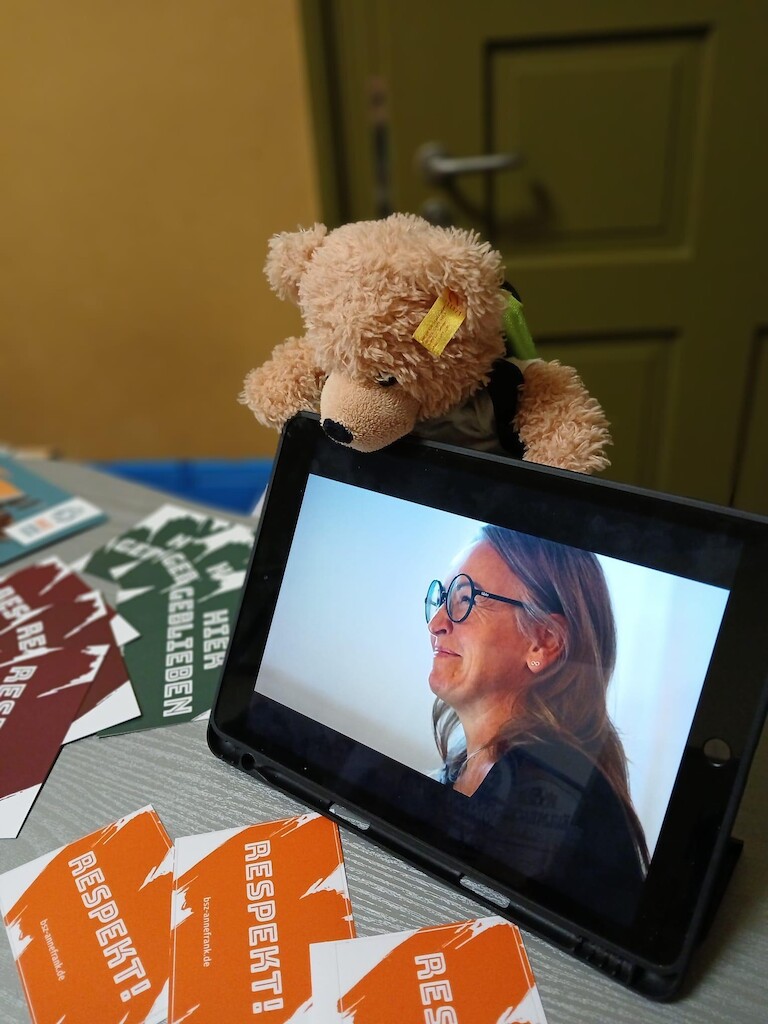 Unser Bär schaut über das Tablet unser Schulvideo an.