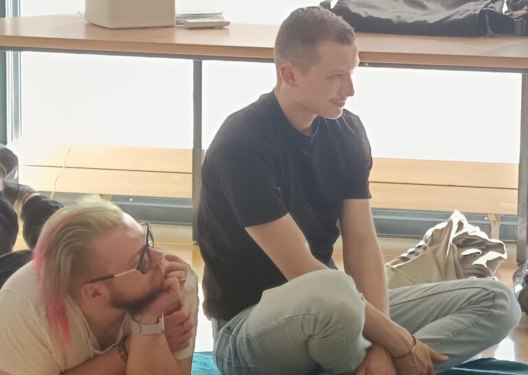 Zwei Schüler hören aufmerksam zu.