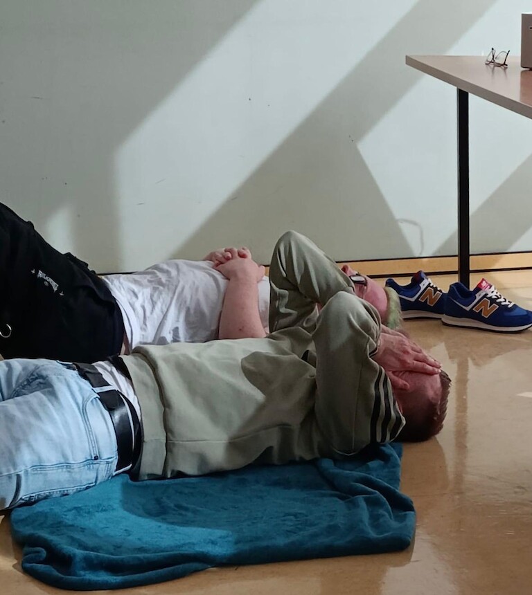 Zwei Schüler liegen auf dem Boden und halten sich die Augen zu.