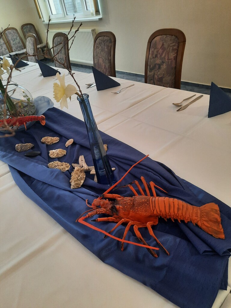 Die Tischdekoration mit dem Krebs und einer Vase.