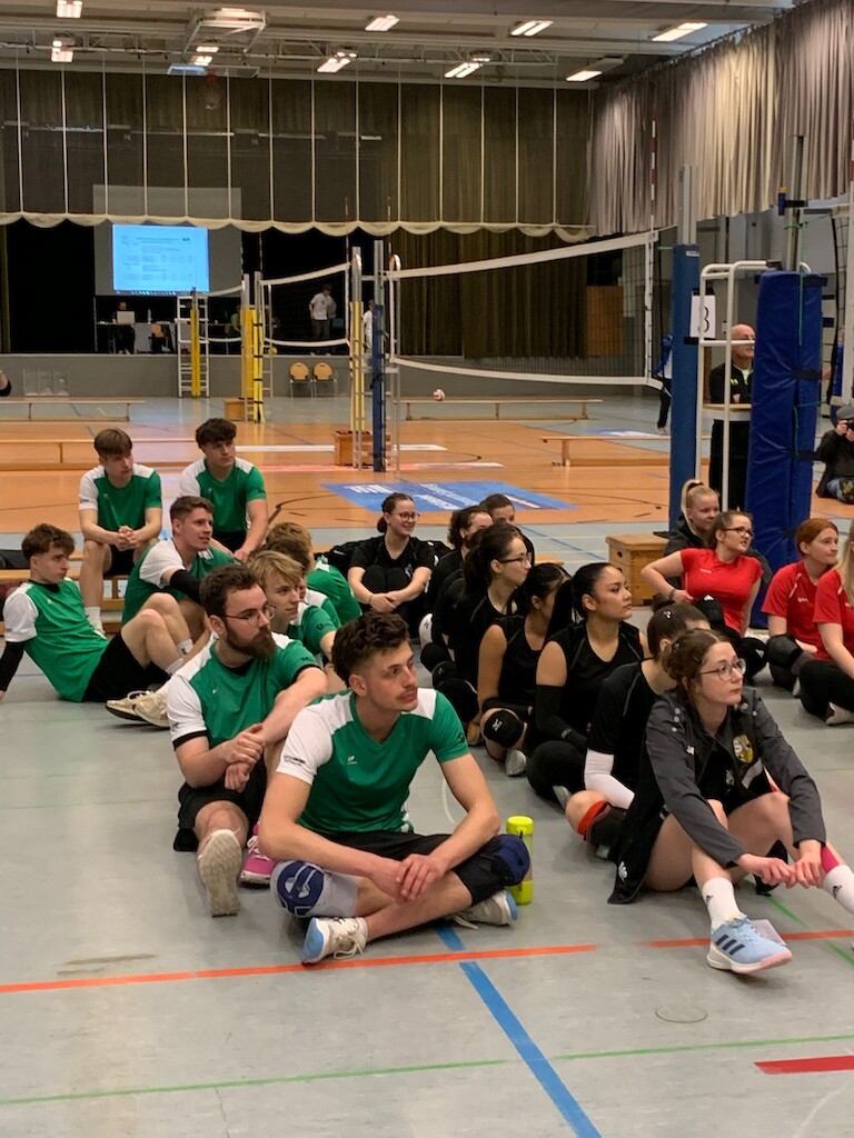 Das Jungen- und Damenteam in wartender Sitzposition.