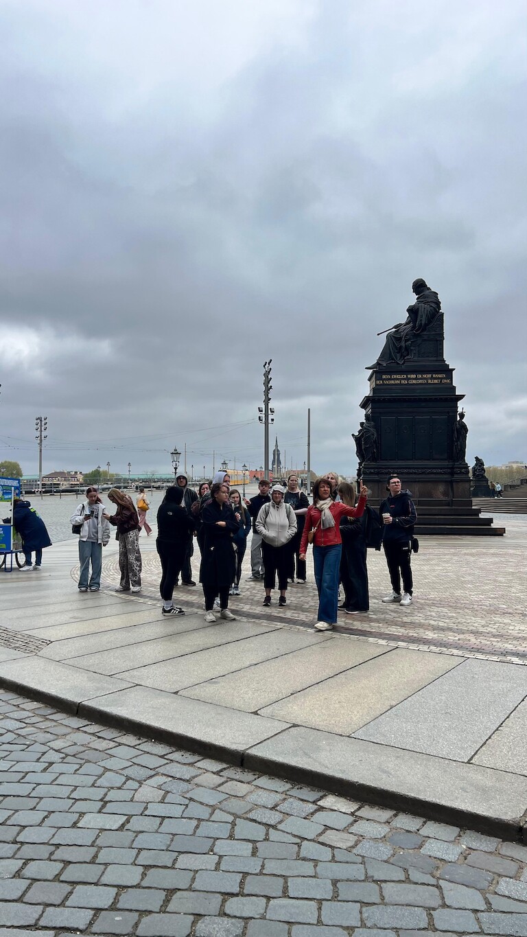 Die Schülerinnen und Schüler vor einer Statue.