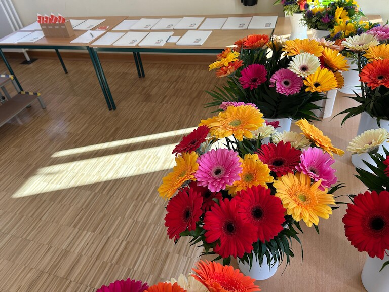 Blumen und Zeugnisse liegen auf den Tischen