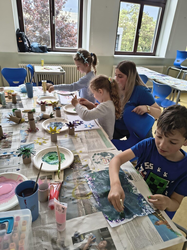 Die Kinder malen am Tisch.