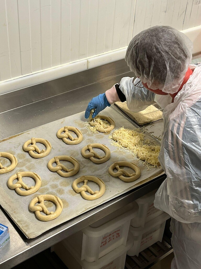 Brezeln werden mit Käse belegt-