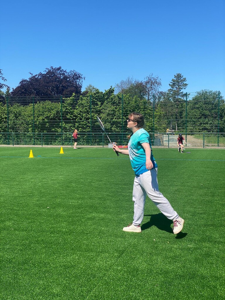 Eine Schülerin beim Federball spielen.